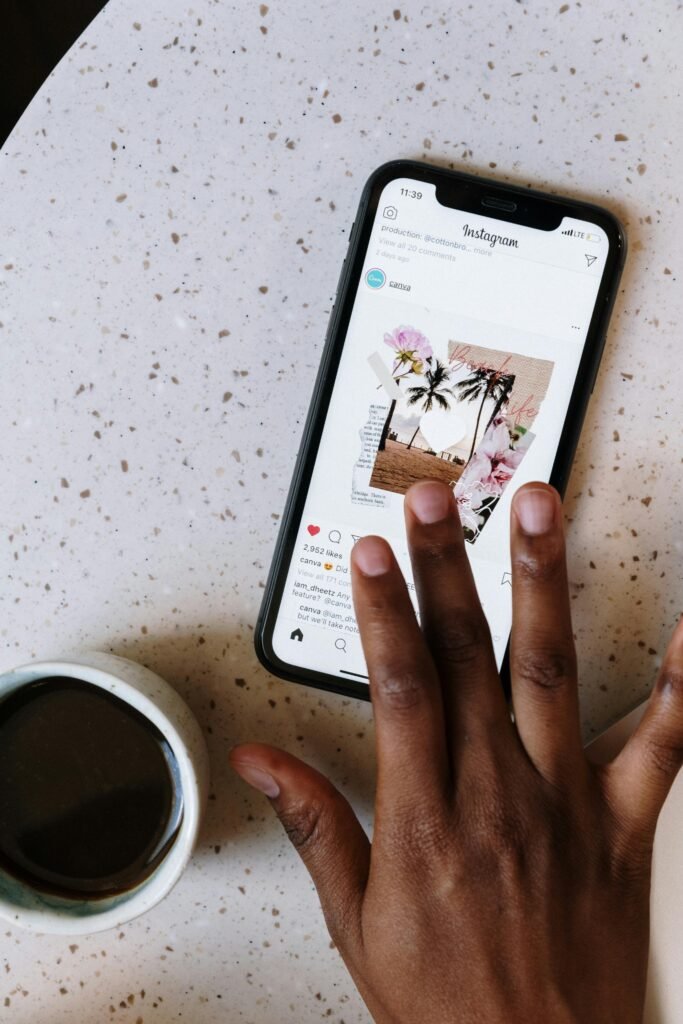 pexels photo 5052877 5052877 Close-up of hand scrolling Instagram on smartphone near coffee cup on table.